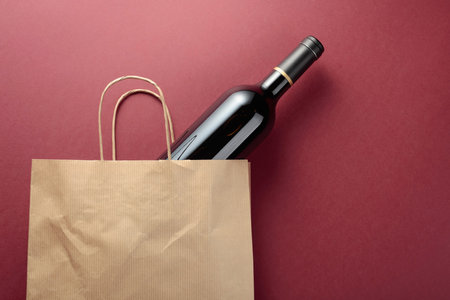 Recycled paper shopping bag with a bottle of red wine. Top view, copy space.の写真素材