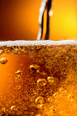 Glass of tasty beer with foam, closeup. Pouring beer with bubble froth in glass for background and design.の写真素材