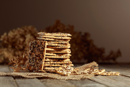 Crispy crackers with sunflower and flax seeds on an old wooden table. Simple healthy food. Copy space.の写真素材