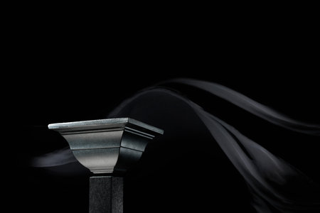 Luxury black podium on a background of waving black silk curtain. Perfect platform for showing your products on a dark background.の写真素材