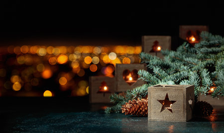 Christmas still-life with spruce branches and burning candles in old wooden lanterns. Copy space.