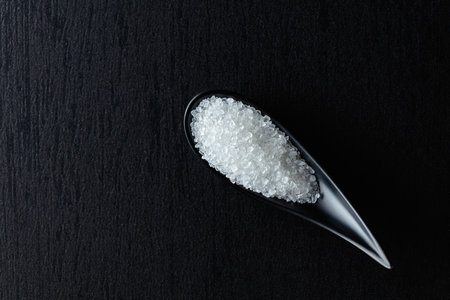 White sea salt on a black ceramic table. Copy space.の写真素材