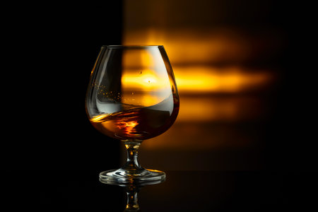 Snifter of brandy on a black background with copy space.