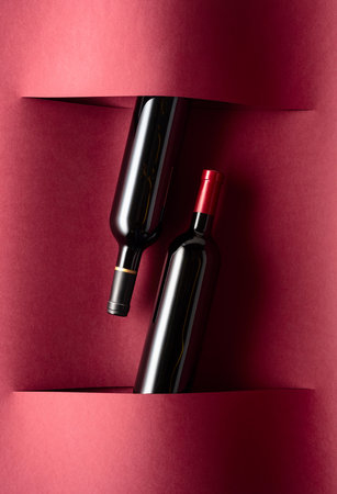 Bottles of red wine on a red background. Top view.の写真素材
