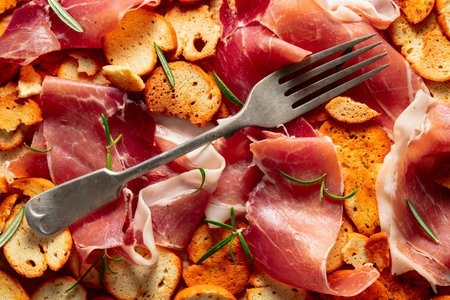 Prosciutto and bruschetta sprinkled with rosemary. Top view. Concept of traditional Italian cuisine.の写真素材