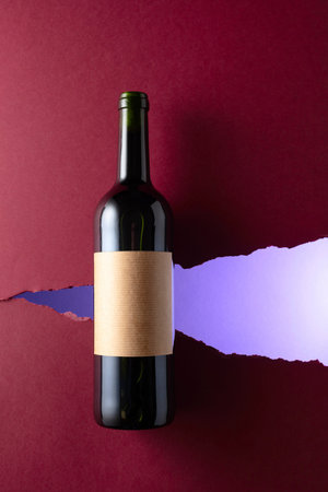 Bottle of red wine with old empty label on a dark red background. Top view.の写真素材