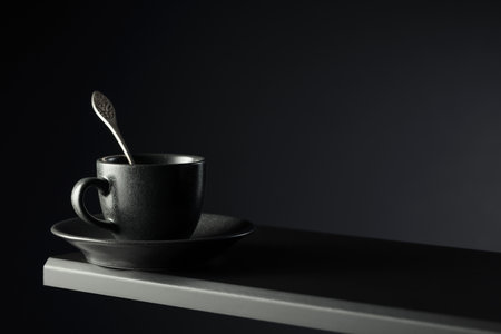 Black cup of coffee on a black background. Copy space.の写真素材
