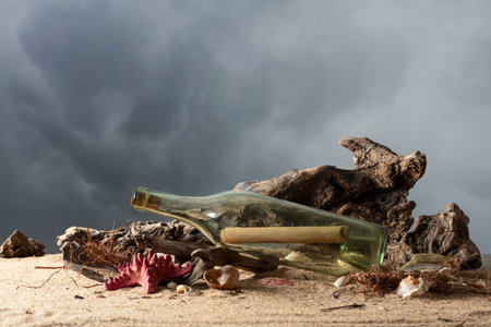 Message in a vintage bottle on a sea shore. Bottle with snags, shells, and stones on a sea sand.