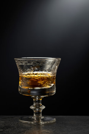 Brandy snifter on a black stone table. Copy space.の写真素材