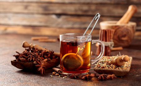 Christmas herbal tea with cinnamon, anise, and dried herbs. Herbal tea with spices in wooden dishes on an old brown table.の写真素材
