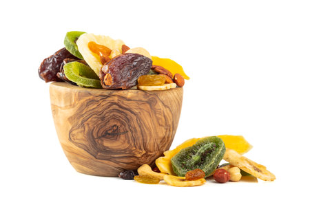 Dried tropical fruits, nuts, and raisins isolated on a white background. Dried fruits in wooden dish.の写真素材