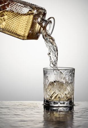 Whiskey is poured into a glass with ice. Copy space.の写真素材