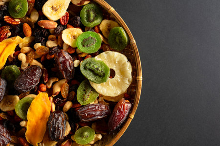 Dried tropical fruits with various nuts and raisins on a black background. Top view.の写真素材