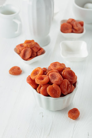 Organic dried apricots on a white wooden table.の写真素材