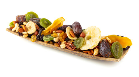 Dried tropical fruits, nuts, and raisins isolated on a white background. Dried fruits in wooden dish.の写真素材