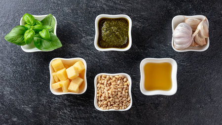 Ingredients for making pesto sauce: basil, pine nuts, garlic, parmesan, and olive oil. Traditional Italian pesto recipe. Top view, copy space.の写真素材