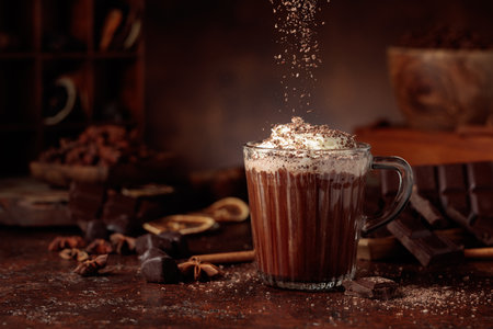 Hot chocolate topped with whipped cream and sprinkled with chocolate chips. A chocolate drink featuring ingredients set against a vintage brown background.の写真素材