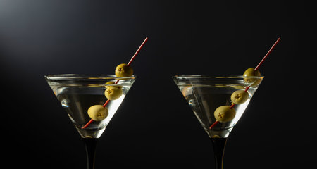 Classic dry martini cocktail with green olives on a black background. Free space for your text.の写真素材