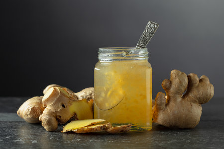 Ginger jam in jar and fresh ginger on a black background. Copy space.の写真素材