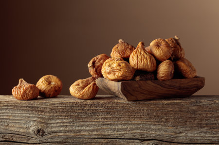 Organic dried figs in a wooden dish on a brown background. Copy space.の写真素材