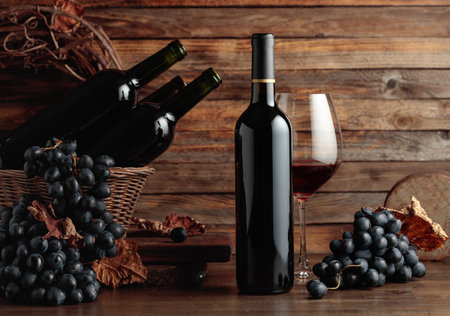 Red wine and blue grapes. Wine and grapes in a vintage setting on an old wooden table.の写真素材