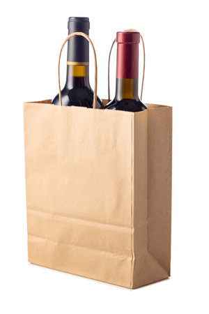 Bottles of red wine in paper bag isolated on a white background.の写真素材