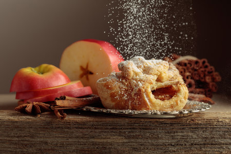 Viennese strudel with apple and cinnamon on old wooden table. Fresh baked goods sprinkled with powdered sugar.の写真素材
