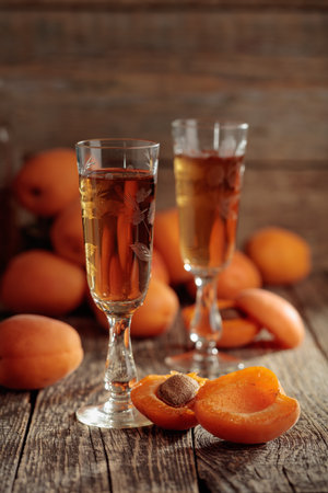 Apricot liquor and fresh apricots on an old wooden table. Wine and juicy fruits on wooden background.の写真素材