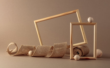 Wooden frames and burlap ribbon on beige background. Copy space.の写真素材