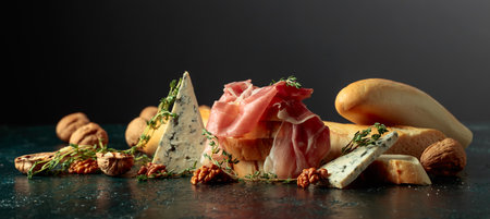 Delicate prosciutto with blue cheese, crispy baguette, crunchy walnuts, and fragrant thyme. A perfect Mediterranean harmony of flavors and textures.の写真素材