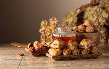Baklava with walnuts and honey on a beige background. Traditional East desert in wooden dish. Copy space.の写真素材