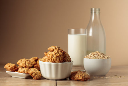 Oatmeal cookies and milk sit on a kitchen table. Beige background with copy space.の写真素材