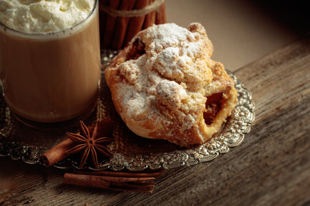 Vienna strudel and caffe latte on a silver tray. Fresh pastry with anise and cinnamon sprinkled with icing sugar.の写真素材