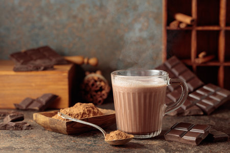 Hot chocolate drink on a brown background. A mug of hot chocolate with broken bitter chocolate bars and cocoa powder. Copy space.の写真素材