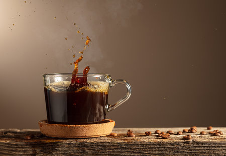 Black coffee in glass cup on a brown background. Copy space.の写真素材