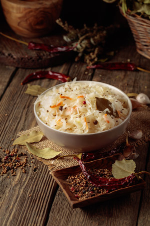 Traditional German sauerkraut with spices on an old rustic wooden table.の写真素材