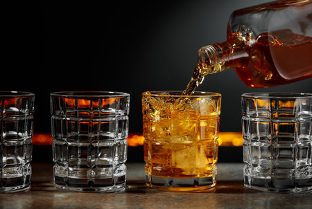 Whiskey is poured into a glass with ice. Copy space.の写真素材