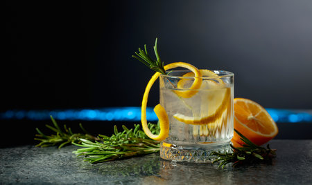 Refreshing gin-tonic cocktail with lemon and rosemary on a black background. Copy space.の写真素材