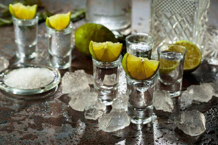 Mexican tequila with lime, sea salt, and crushed ice on a wet vintage background.の写真素材