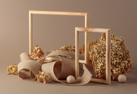 Wooden frames, burlap ribbon and dried hydrangea blossoms on beige background. Background for natural organic product and packaging. Copy space.の写真素材