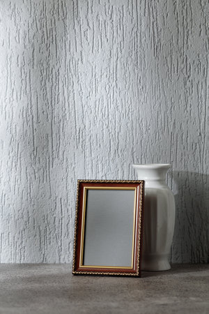 Empty picture frame on a gray background. Wooden frame with golden ornament. Place your image in the frame. Copy space.の写真素材