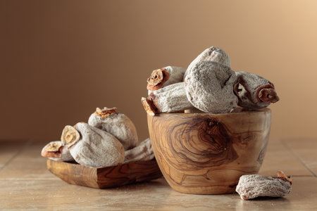 Dried persimmons on a ceramic table. Beige background with copy space.の写真素材
