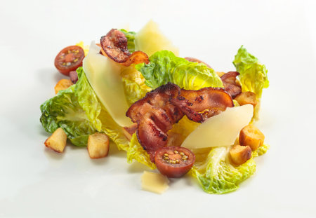 Green salad with grilled bacon, hard cheese, tomato, and croutons.の写真素材