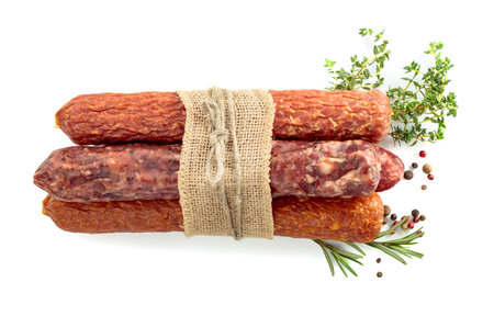 Dry cured sausages with peppercorns, thyme, and rosemary isolated on a white background.の写真素材