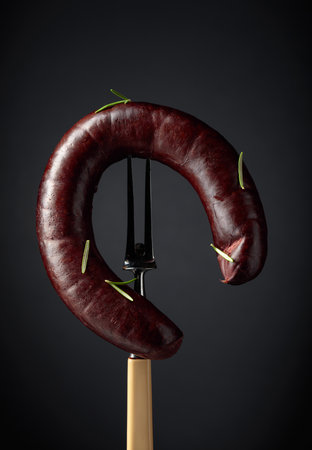 Black pudding or blood sausage with rosemary on a fork.の写真素材
