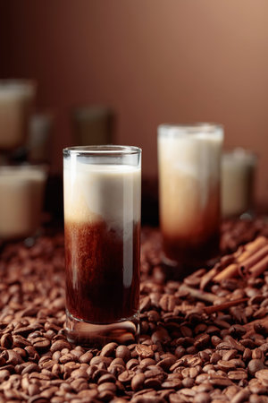 Irish coffee liquor with cream. Coffee beans, cinnamon, and anise are scattered on the table.の写真素材