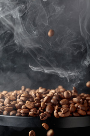 Steaming coffee beans in movement on a black background.の写真素材