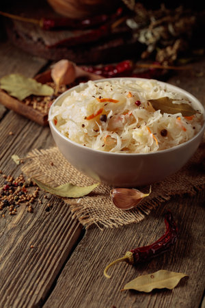 Traditional German sauerkraut with spices on an old rustic wooden table.の写真素材