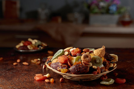 Dried tropical fruits, nuts, and raisins on a brown kitchen table. Copy space.の写真素材