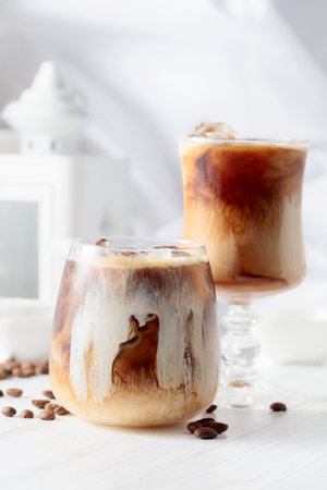 Iced coffee with cream and natural ice on a white wooden table.の写真素材